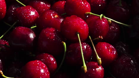 cerezas dulces rojas maduras de cerca con gotas de agua en la canasta en la hierba