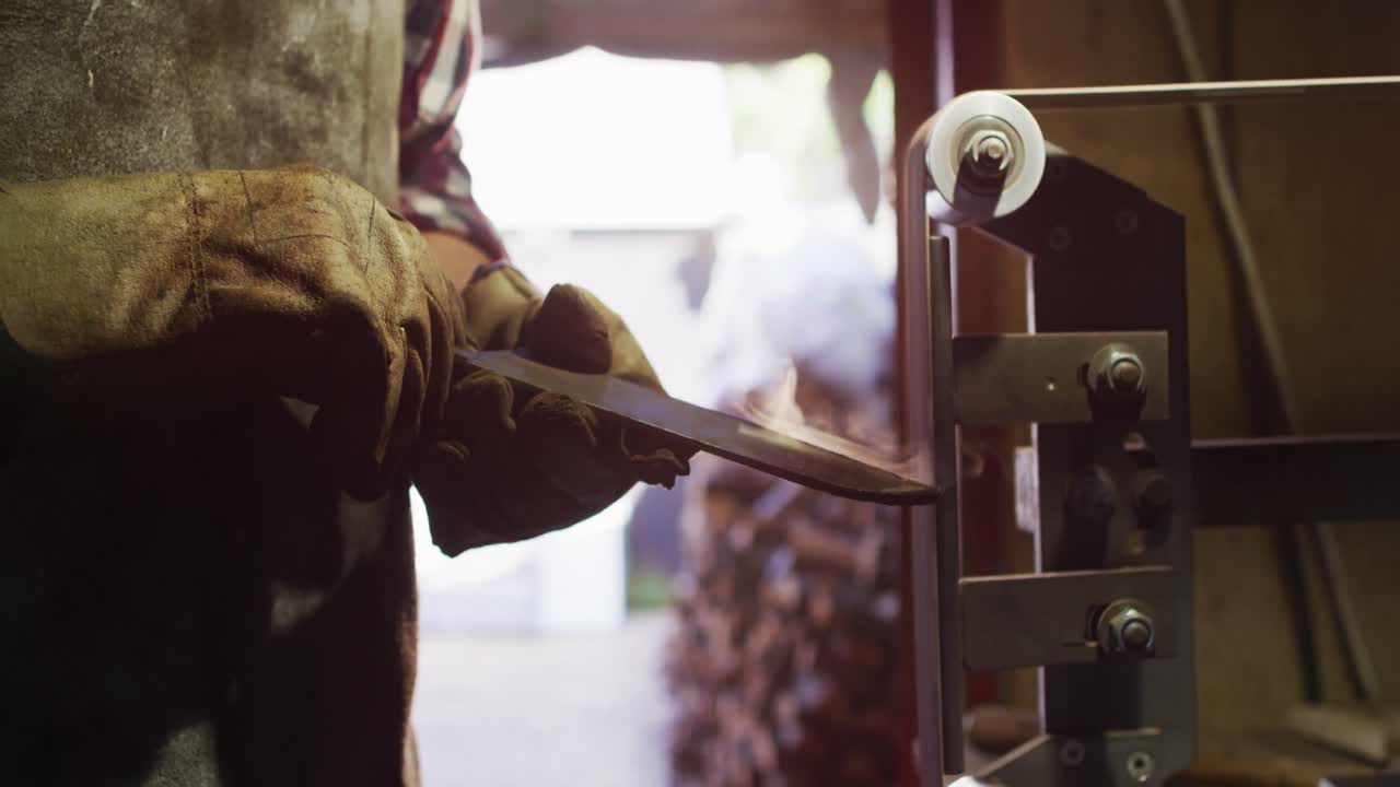 샌더 를 사용 하는 작업실 에서 백인 남성 칼 제작자 의 손 을 가까이 들여다보십시오