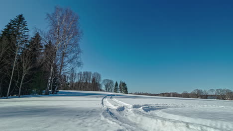 Sombras-En-Un-Campo-Nevado-Con-Rastros,-Lapso-De-Tiempo-De-Atardecer-Panorámico-Con-Cielo-Azul