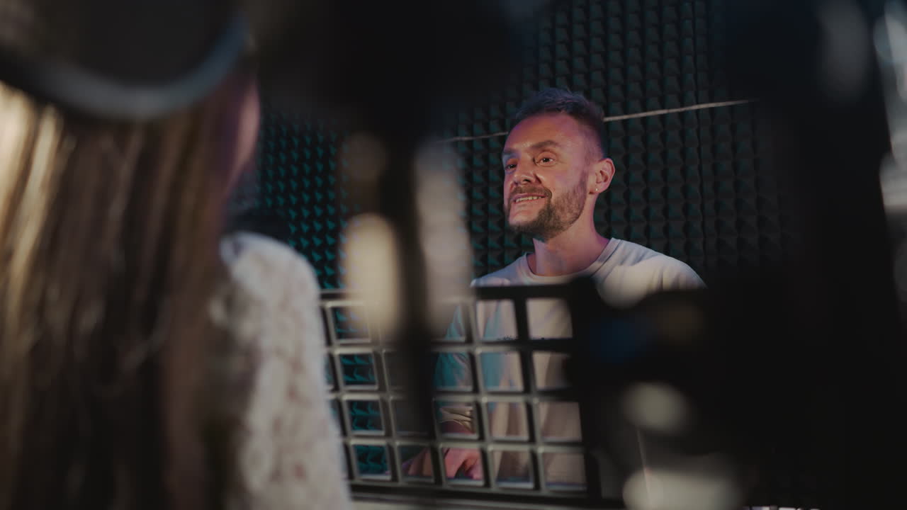 Teacher conducts music lesson to kid in studio. Happy mentor plays synthesizer while little girl sings in sound insulated room. Children development