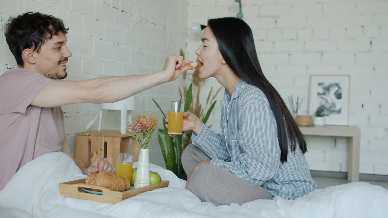 침대에서 아침 식사를 즐기는 커플