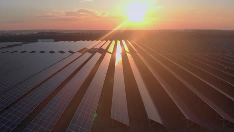 aerial drone view into large solar panels at a solar farm at cloudy summer evening. solar cell power plants, green grass. footage video 4k.
