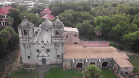 a drone captures an aerial ascent shot of the front of mission concepcion in san antonio, texas