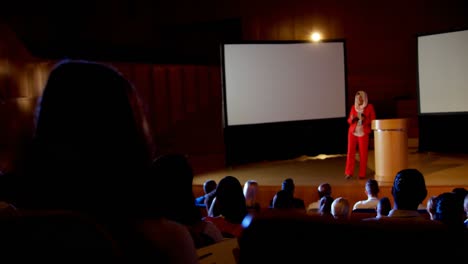 mujer de negocios caucásica madura con hijab hablando en un seminario de negocios en el auditorio 4k