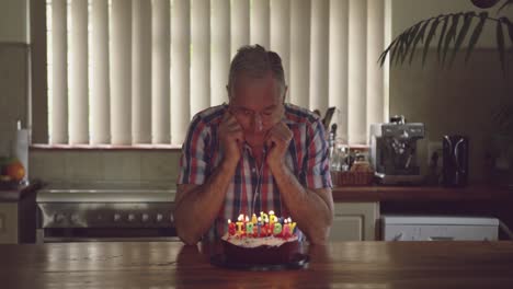 hombre mayor con un pastel de cumpleaños en casa