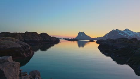 cliff islands near rocky coast with snowy mountains in the background