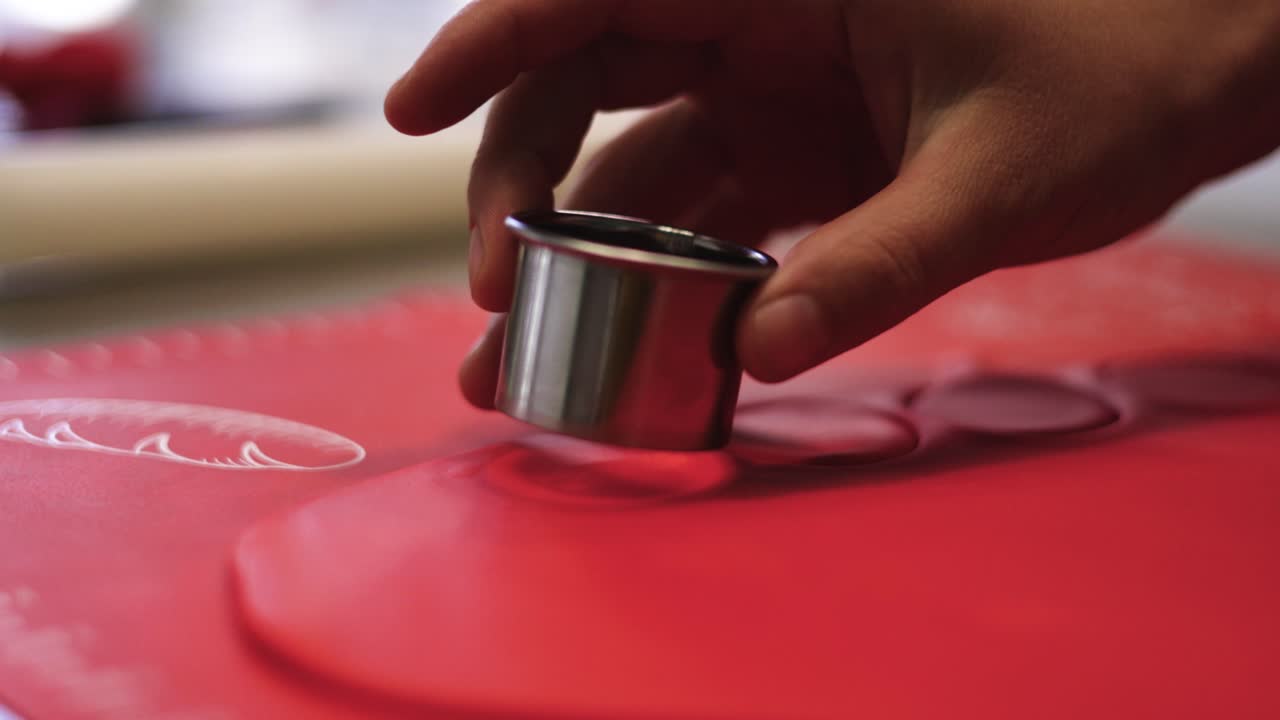 chef de pastelería corta la masa de pastel rojo con forma redonda, toma en cámara lenta