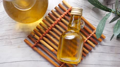 botella pequeña de aceite de oliva con aceitunas y rama de oliva
