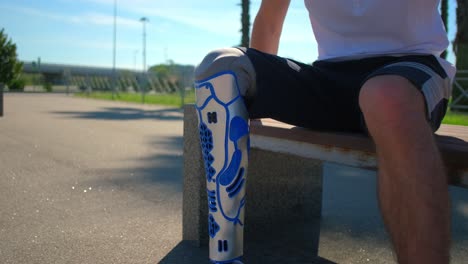 person with prosthetic leg sitting on a park bench