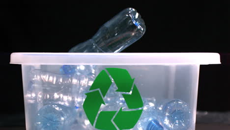 botella que cae en el contenedor de reciclaje