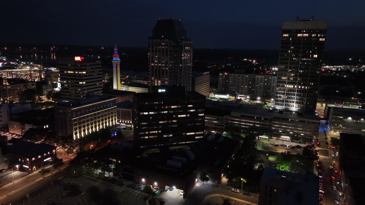 Lighting city skyline of Springfield, Massachusetts’s at night. Mirrored high-rise buildings and skyscrapers. Traffic on road in background. Downtown scene in American town. Aerial wide shot