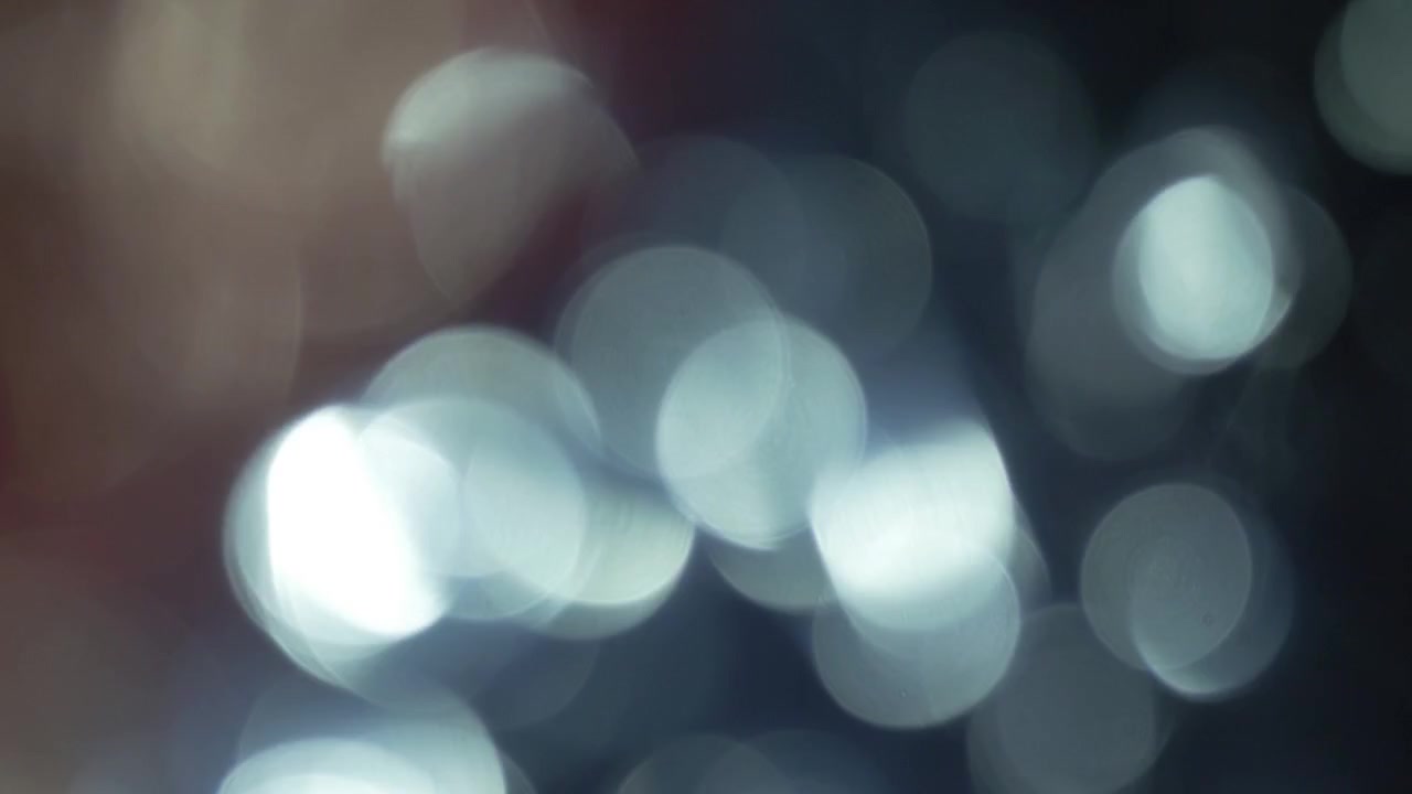 Particelle di luce bokeh morbide e scintillanti su sfondo nero