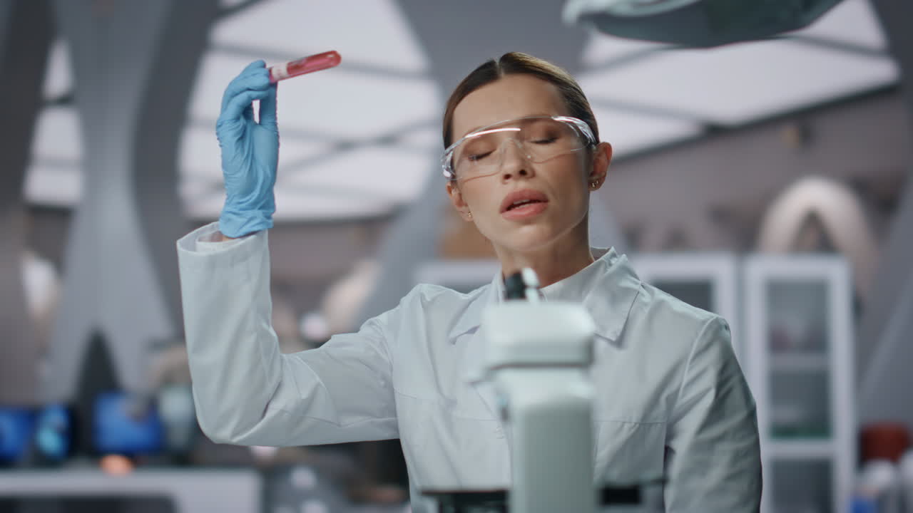 расстроенный ученый, глядящий в пробирку, неудовлетворенный результатами исследований вблизи.