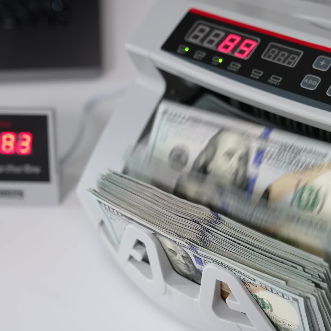 Elektronisk tellemaskin for penger på det hvite bordet. UDS-dollar beregnet i det finansielle utstyret. Høyt perspektiv. Nærbilde.