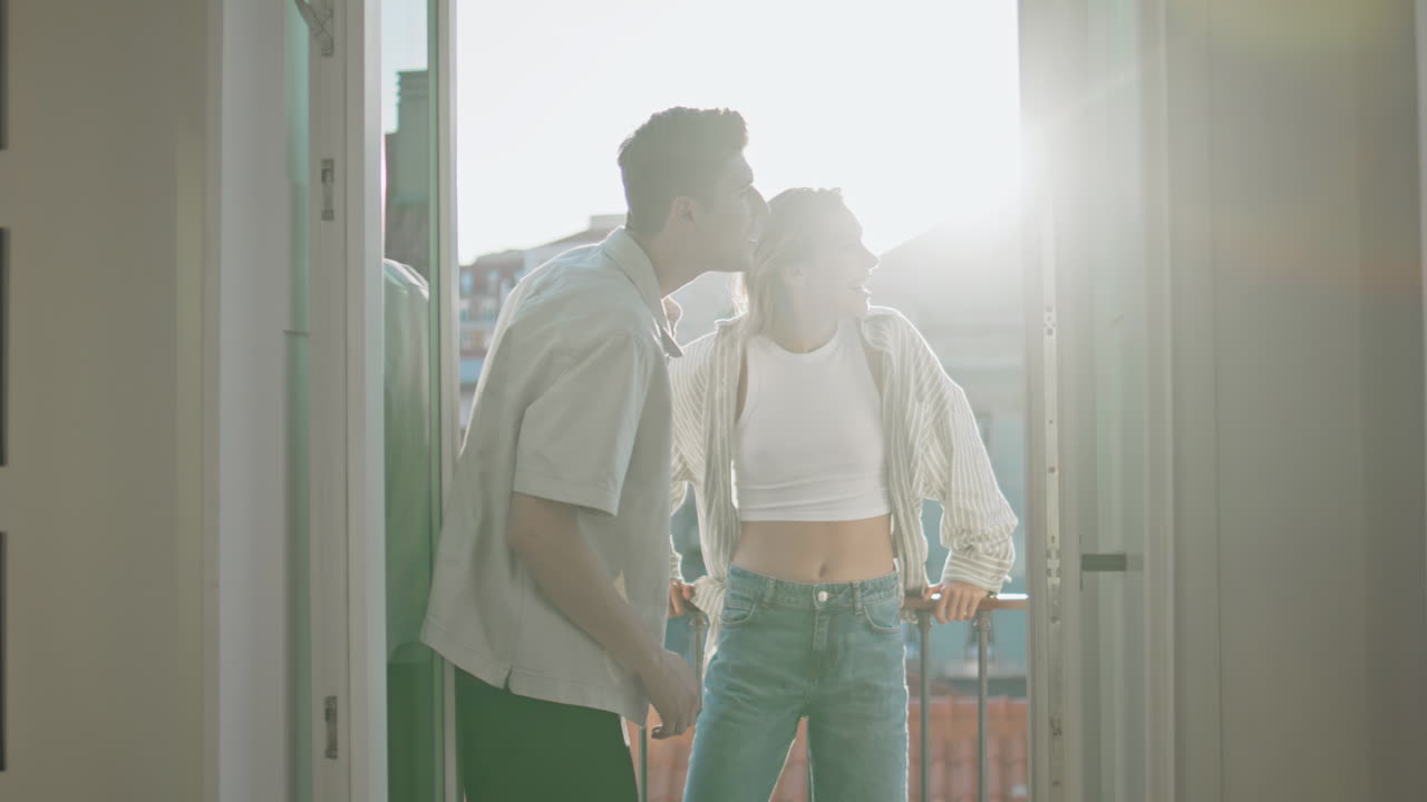 Romantic people enjoying cityscape on balcony. Smiling sweethearts talk on date