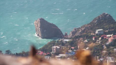 rocky coastline with waves and cityscape