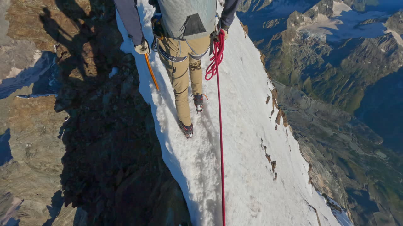 First-person POV of a climber ascending the iconic Matterhorn at sunrise on a crystal-clear bluebird day. Captured on GoPro for an immersive, realistic mountaineering experience above the clouds