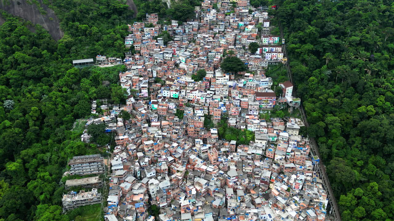 Drone in discesa davanti a vivaci case di quartieri disagiati a Rio de Janeiro, Brasile.