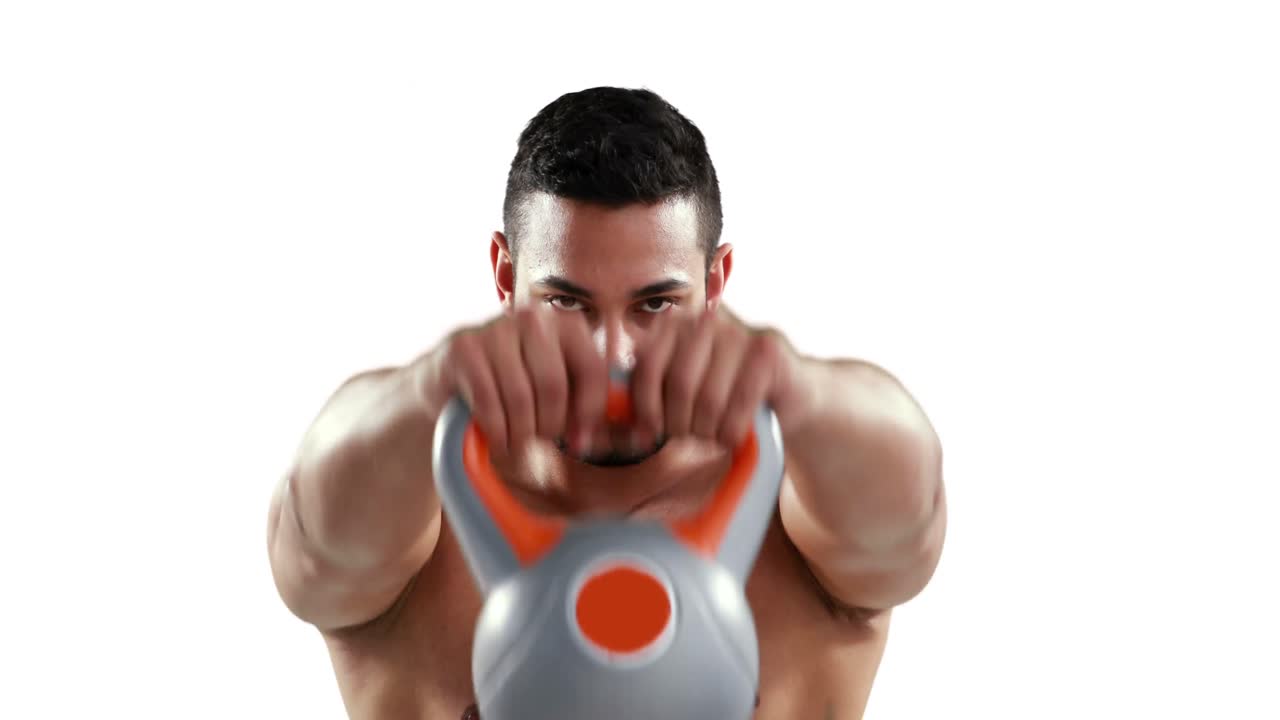 culturista musculoso serio levantando kettlebell