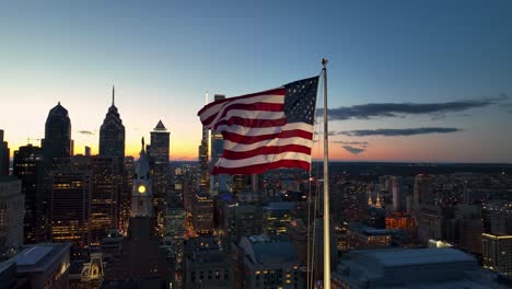 american flag waves in urban city usa