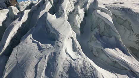 inclinación aérea hacia arriba, glaciar cubierto de nieve con relieve en los alpes suizos en invierno