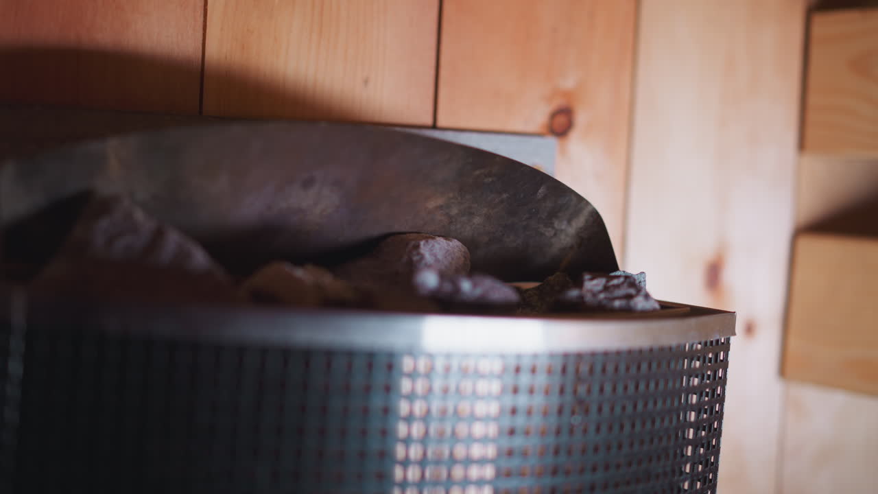 여성은 사우나 클로즈업에서 에센셜 오일의 방울을 사용합니다. 오일들은 사우나에서 폐에 긍정적 인 영향을 미치는 공기를 만드는 데 도움이되며 방문객에게 즐거운 새를 만니다.