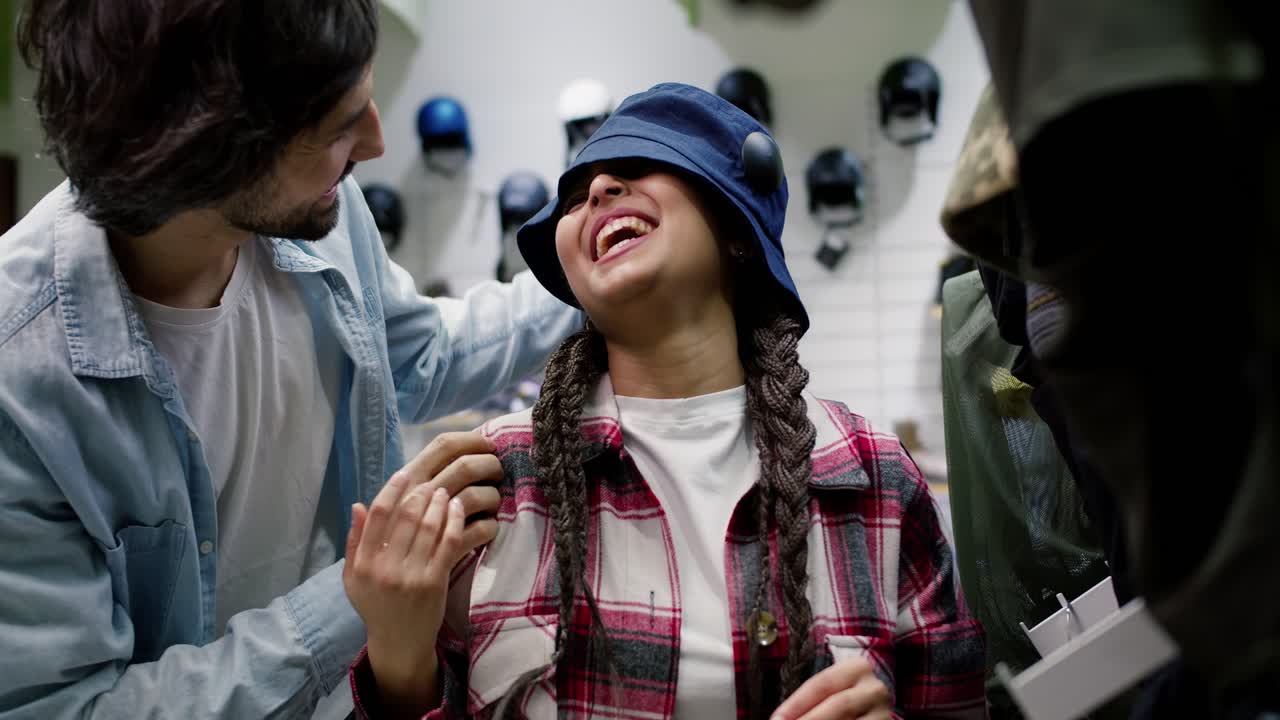 행복 한 커플 이 스포츠 가게 에서 쇼핑 하는 동안 즐거움을 즐기고 있다