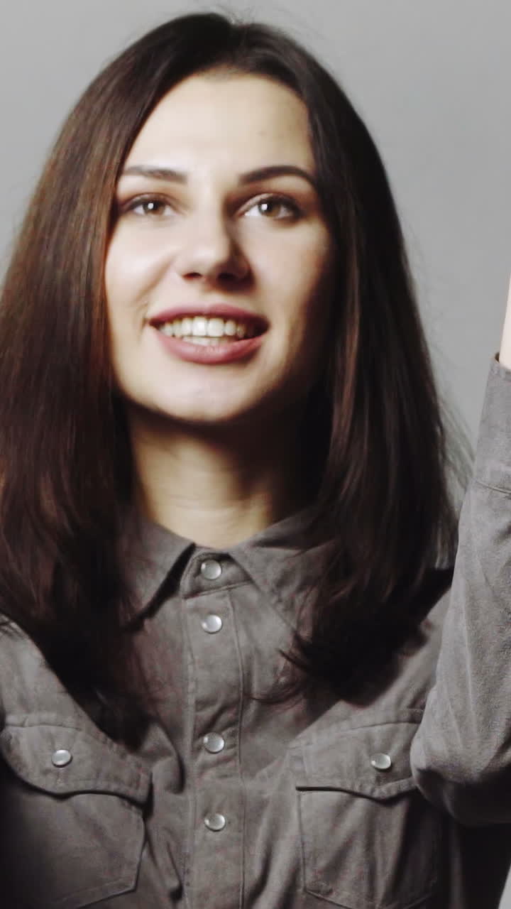 Woman blowing confetti away. Joyful party girl standing and blowing confetti and looking at camera