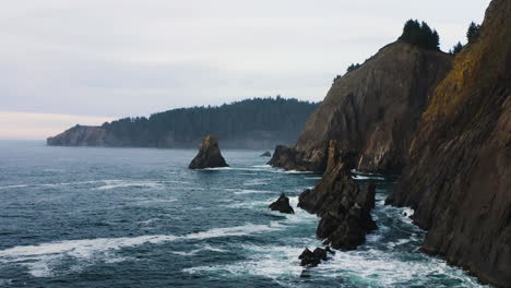 Vuelo-Bajo-Hacia-Las-Agitadas-Aguas-Del-Océano-Pacífico-Hacia-Una-Pequeña-Cala,-Costa-De-Oregon