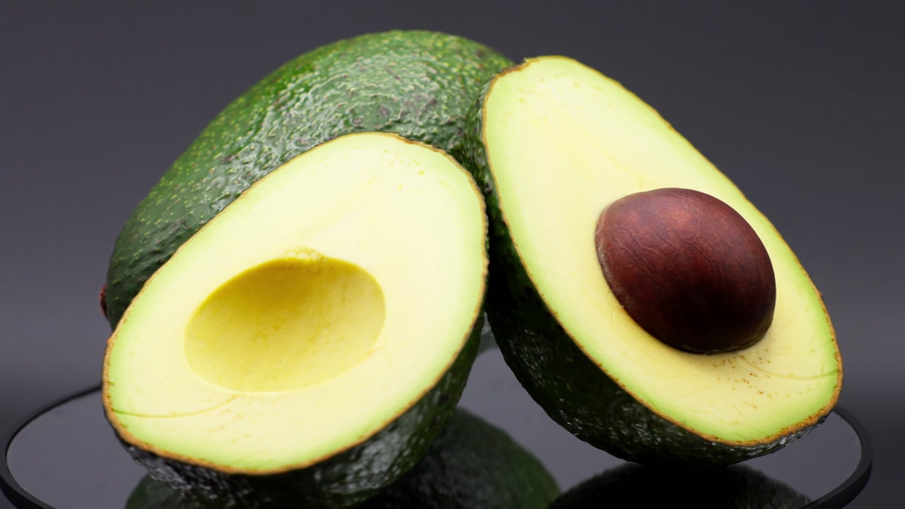 SLOW MOTION CLOSE UP SHOT OF 3 AVOCADOS SLICED ROTATING AT A MIRROR LAZY SUSAN