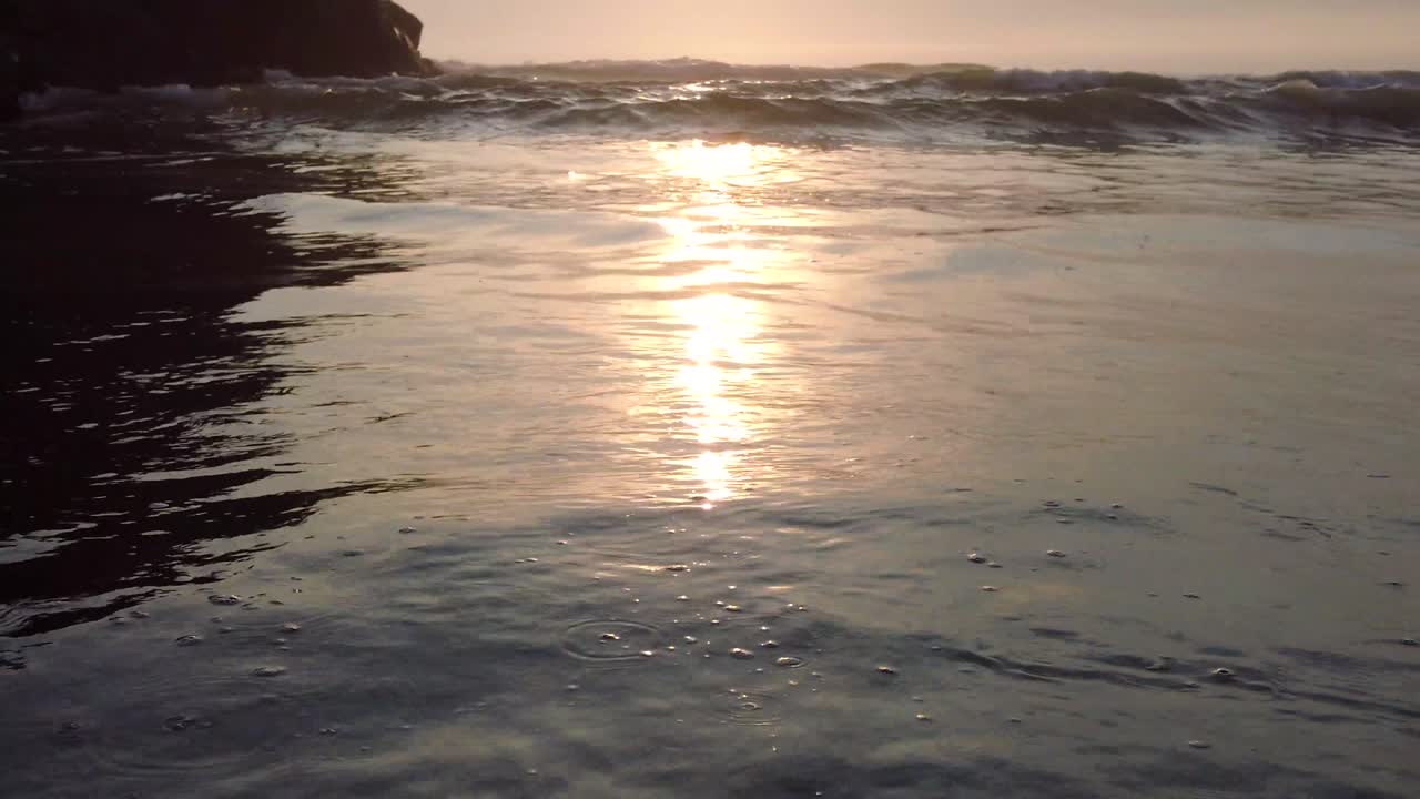 sunset at the beach, ocean waves and sand, no people, golden hour