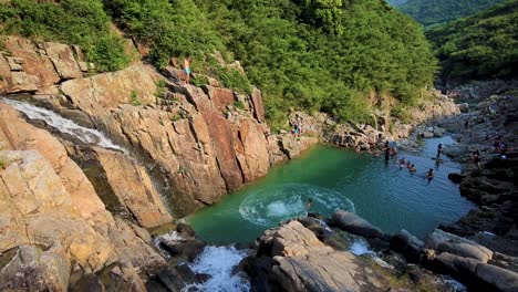 vacationists cliff jumping in adventure at sai kung rock pools in sai kung, hong kong