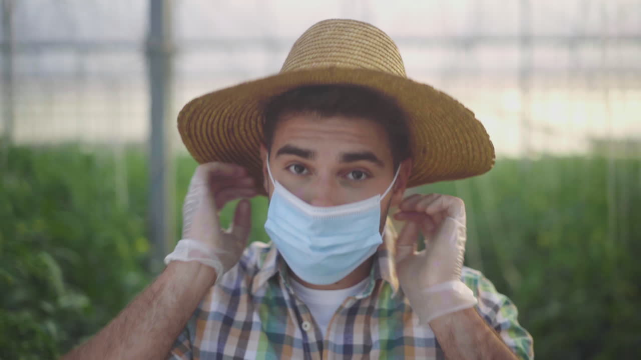 Farmer in Greenhouse with Mask and Gloves
