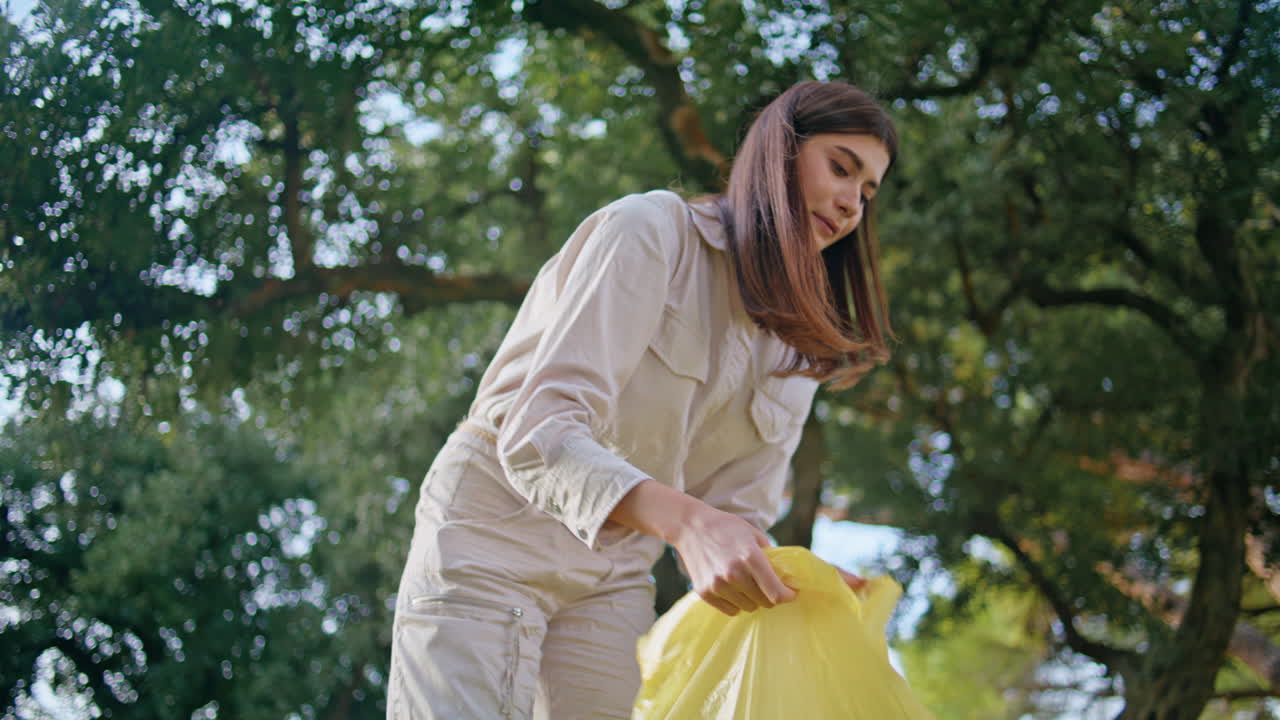 Volunteer cleaning garbage park holding bag. Woman collecting plastic trash