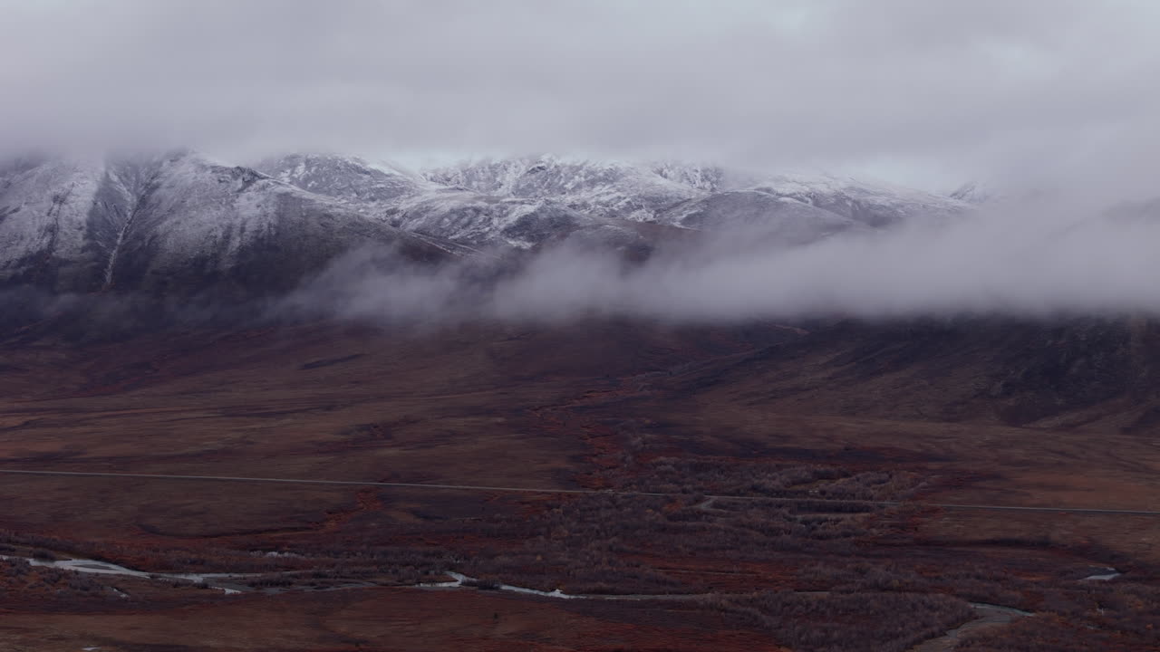 Low Clouds Over Snow Mountains Of Ogilvie Along The Dempster Highway In Yukon, Canada. Aerial Shot