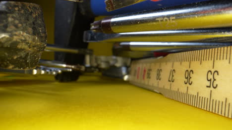 tiro de carro que muestra diferentes herramientas de taller en superficie amarilla
