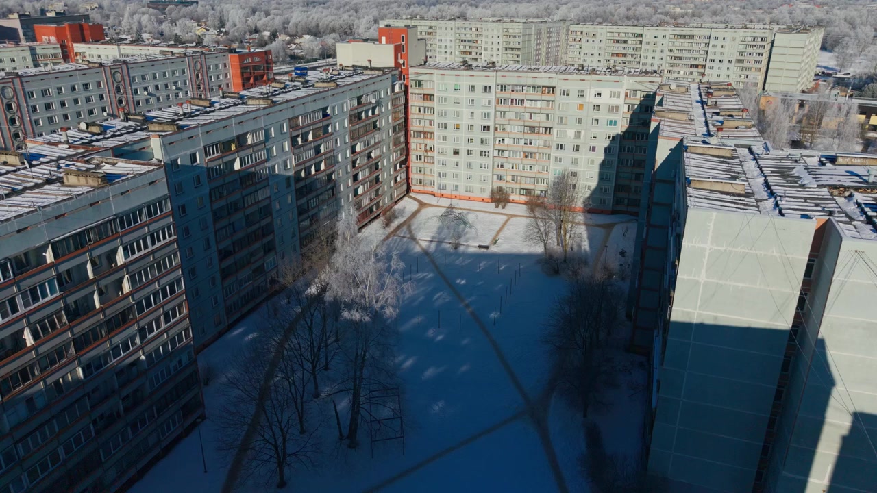 Un dron avanza sobre bloques de apartamentos helados en Ziepniekkalns, Riga