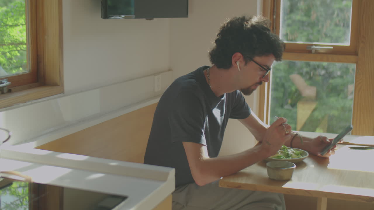 Man Using Phone while Eating at Home