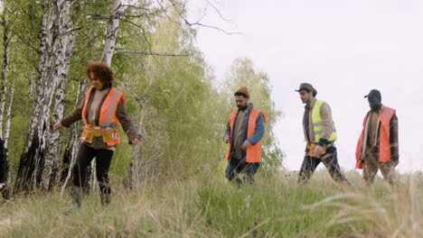 Vista-Lejana-De-Un-Grupo-De-Activistas-Ecologistas-Multiétnicos-Caminando-En-El-Bosque