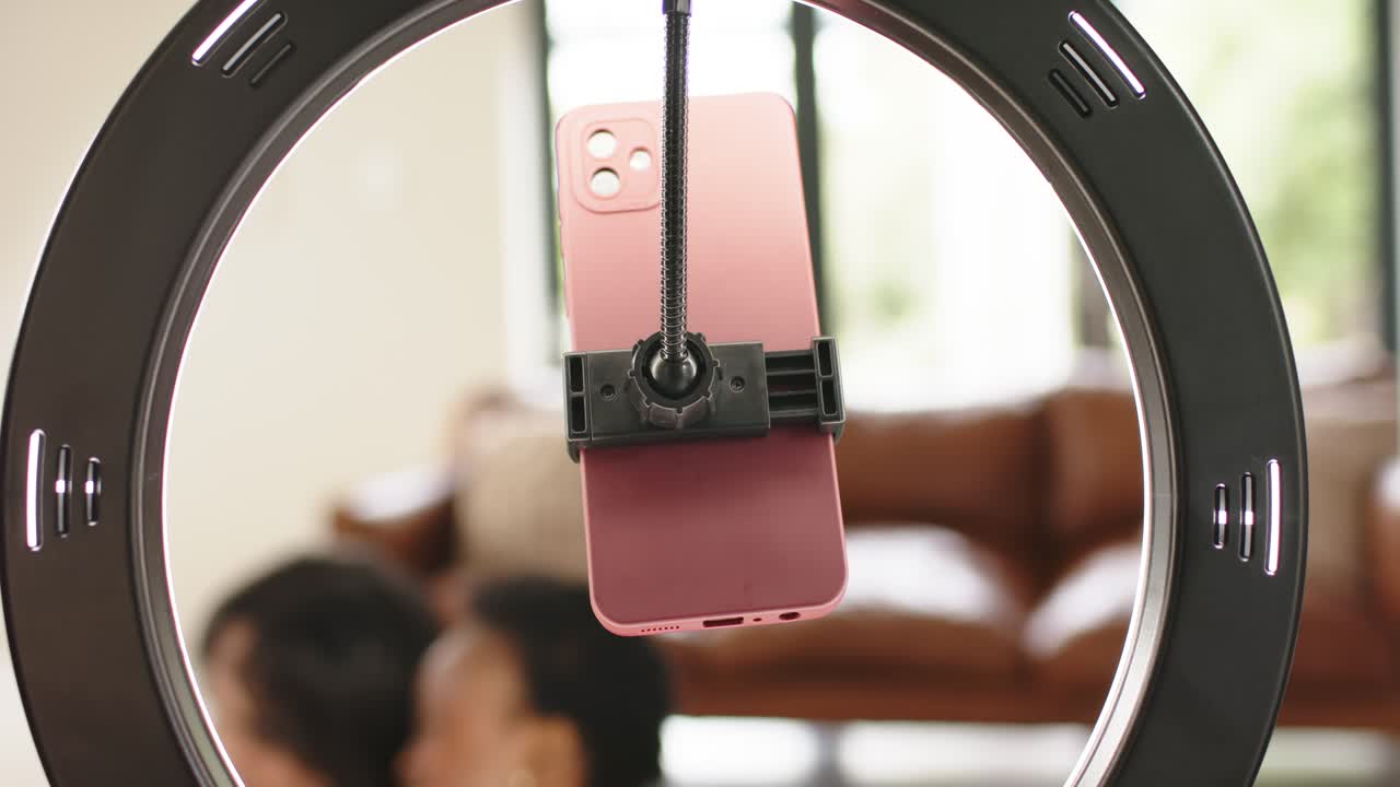 Seeing ring light framing mauve smartphone diverse friends stepping smiling centering faces at home
