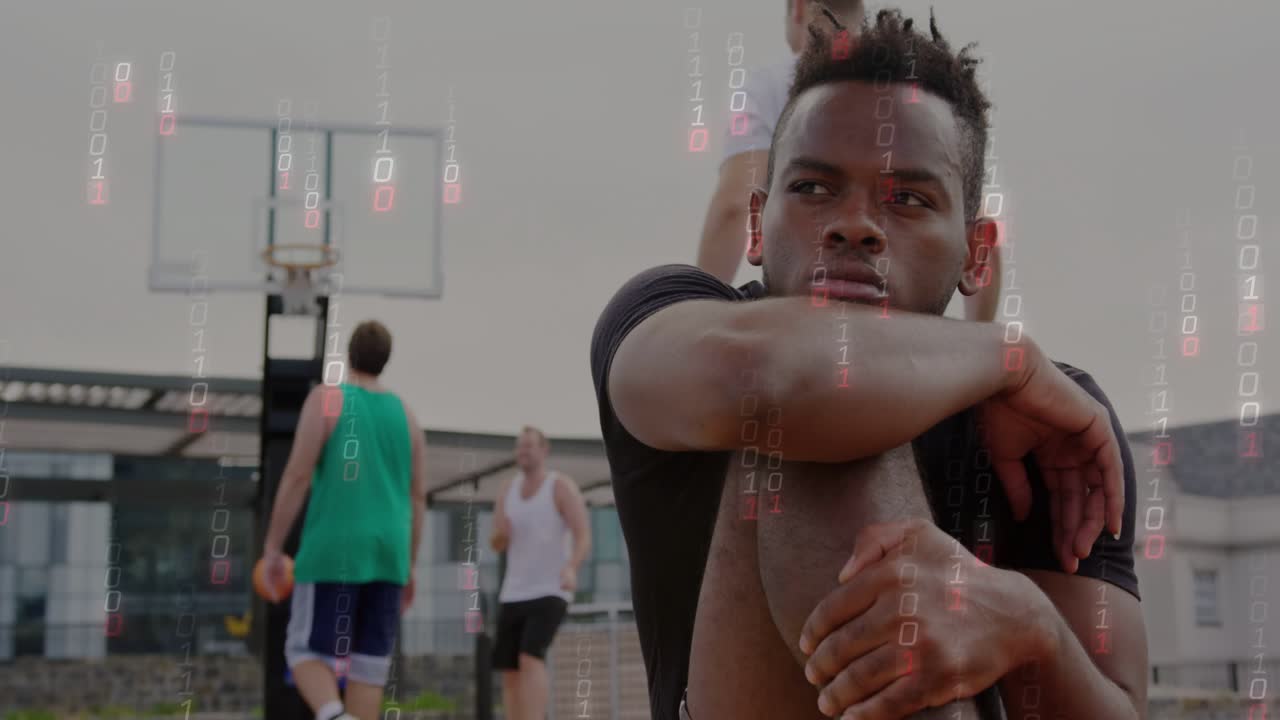 Seated man holding knee, team shooting on sports court causing falling locks, turning joining play