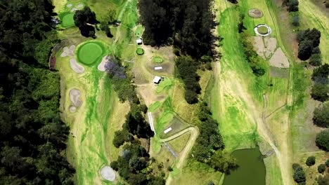 Aerial-View-of-Large-Bright-Green-Golf-Course-Surrounded-by-Forest-in-Ecuador