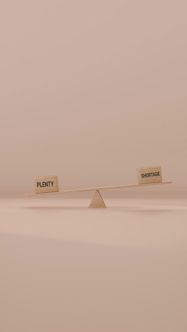 VERITCAL VIDEO OF PLENTY AND SHORTAGE BALANCING ON SEESAW