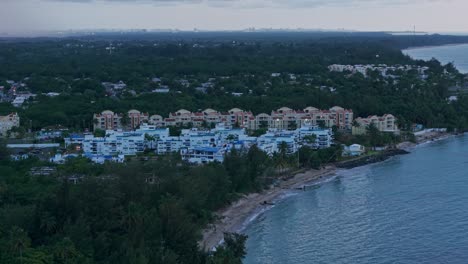 aerial: loiza cityscape with sand beach, atlantic ocean at sunset in puerto rico, usa, establishing drone shot