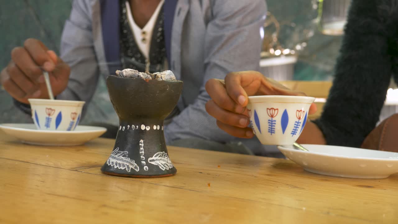 두 마리의 사랑새가 유향의 마법 같은 냄새에 둘러싸여 커피를 마시며 미래 계획을 논의하고 있습니다.