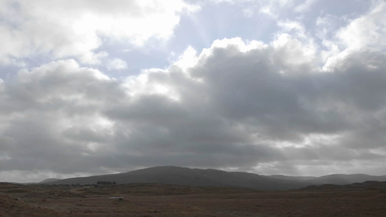 croagleheen ireland의 토탄 습지 위로 구름과 태양 플레어의 시간 경과