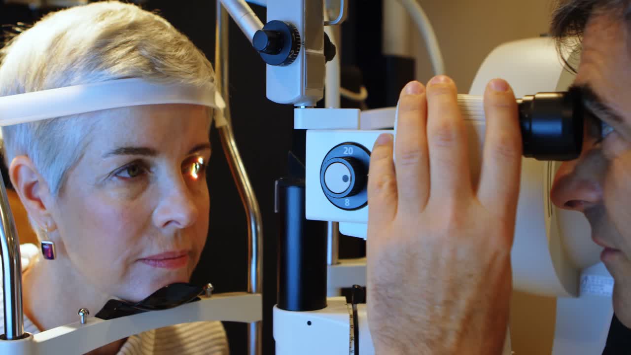 Optometrist examining patient eyes with slit lamp 4k
