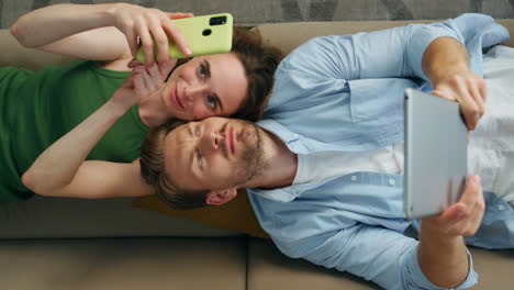 mujer feliz haciendo selfie colocando sofá con el marido vista superior. pareja descansando sofá