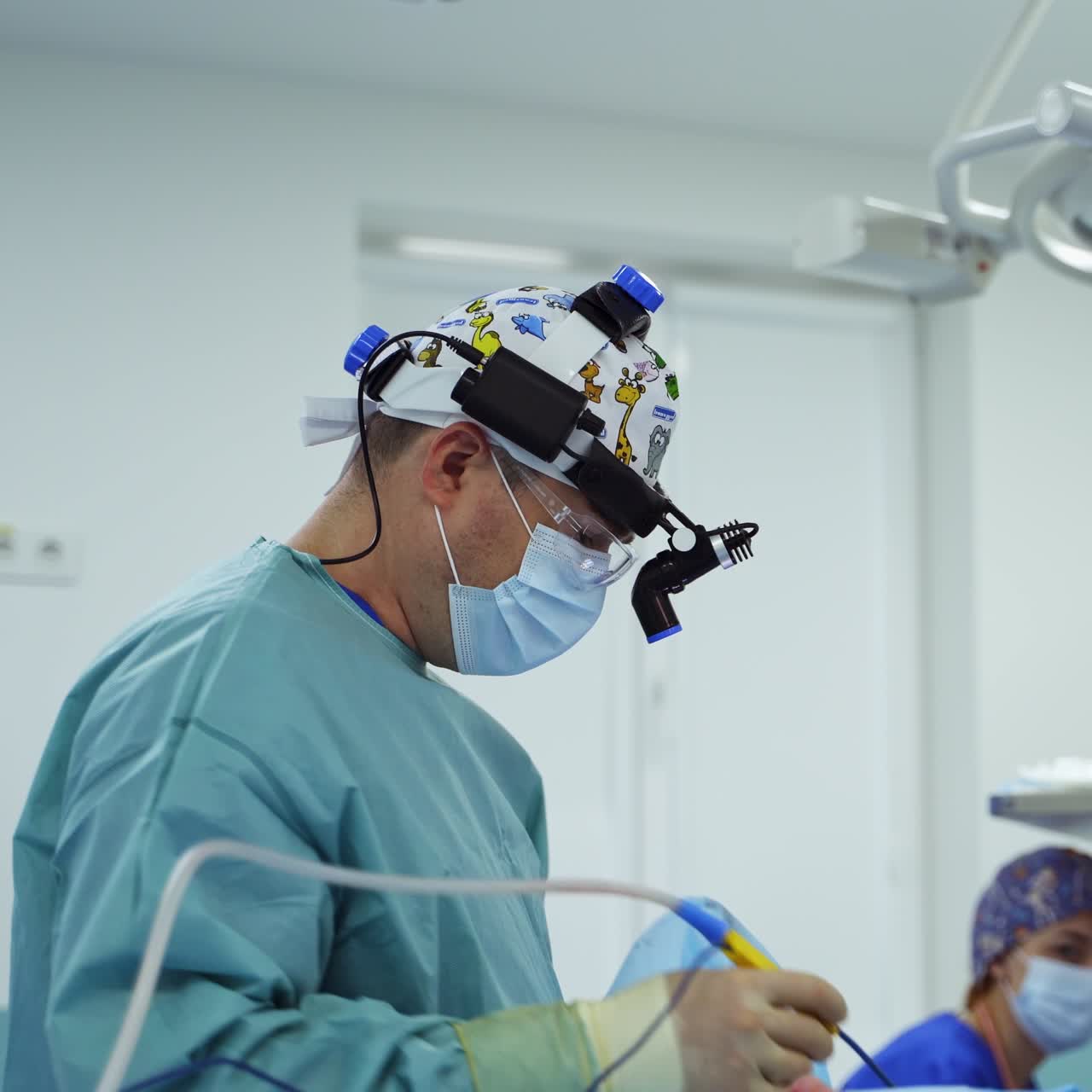 Doctor and assisting nurse at otolaryngology operation. Medics work and communicate during the procedure. Blurred backdrop
