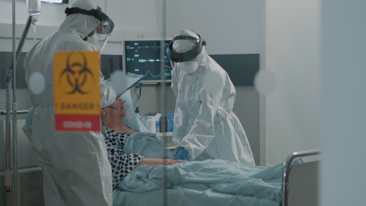 Medical team doing consultation for old patient with coronavirus